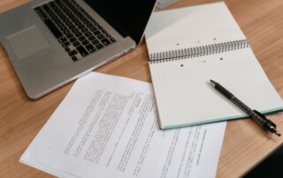 Pen and laptop on a desk representing employee benefits compliance