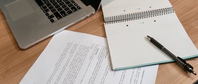 Pen and laptop on a desk representing employee benefits compliance